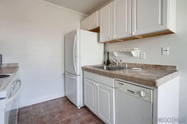 a kitchen with stainless steel appliances granite countertop a sink and a refrigerator