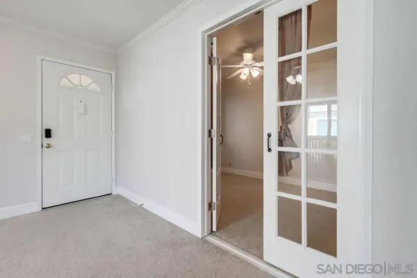 a view of an empty room with cabinet and entryway