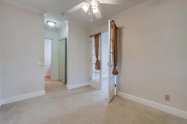 an empty room with closet and a chandelier fan
