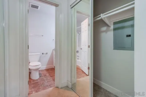a bathroom with a granite countertop toilet and a shower