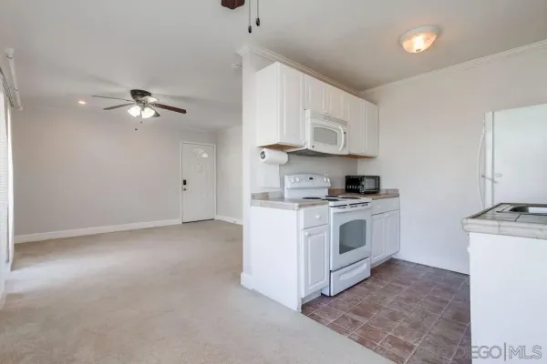 a kitchen with cabinets stainless steel appliances and a chandelier