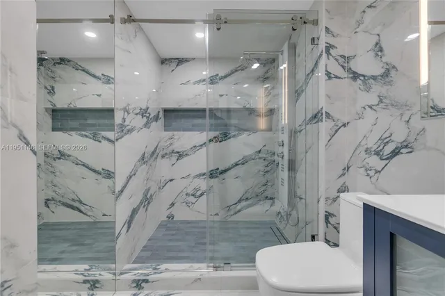 a bathroom with a sink toilet double vanity and shower