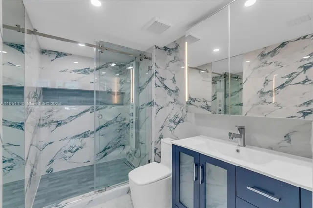 a bathroom with a sink a toilet and a mirror