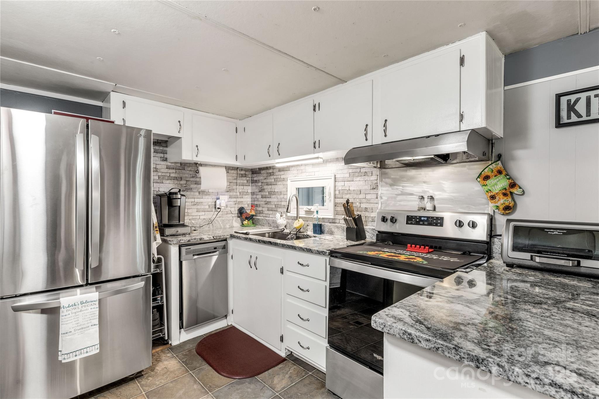 1164 Stroupe Road Lancaster, SC 29720 - Photo 18 of 37 a kitchen with kitchen island granite countertop stainless steel appliances and wooden cabinets