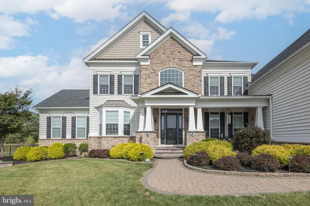 a front view of a house with a yard and potted plants