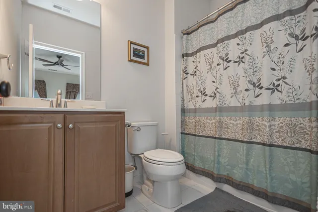 a view of a white house next to a yard with big trees