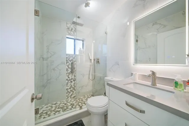 a bathroom with a sink toilet and shower