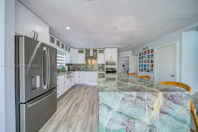 a kitchen with stainless steel appliances granite countertop a refrigerator and a sink