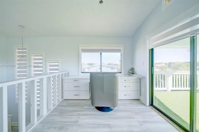 a room with a large window and a dresser