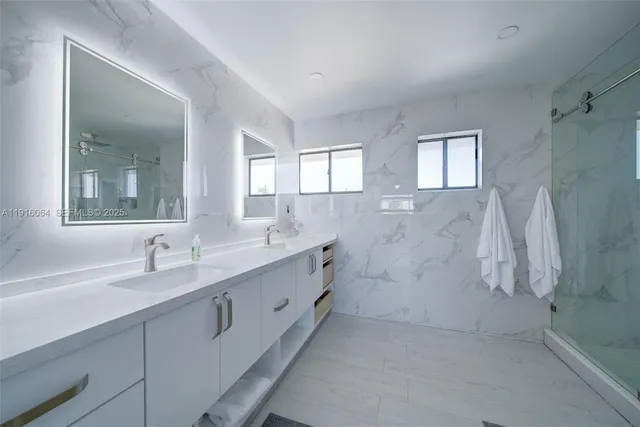 a bathroom with a double vanity sink a mirror and a bathtub