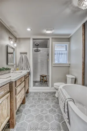 a spacious bathroom with a double vanity sink a mirror and a bathtub