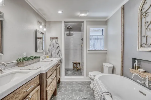 a spacious bathroom with a tub sink and mirror