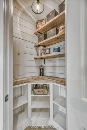 a view of a refrigerator in kitchen and white cabinets