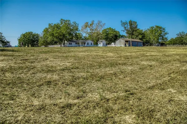 a view of a field with trees in the background
