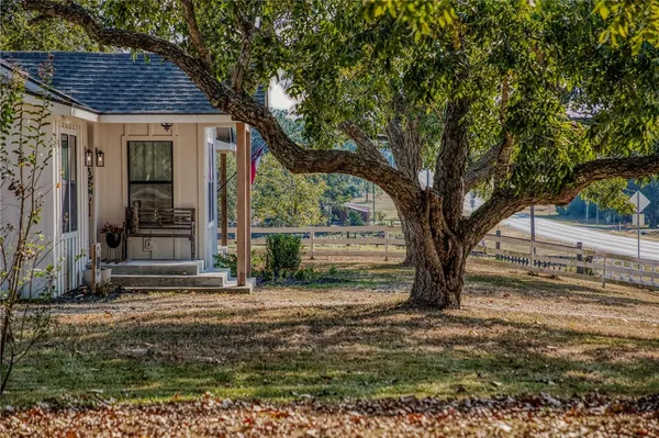 a view of a house with backyard and a tree