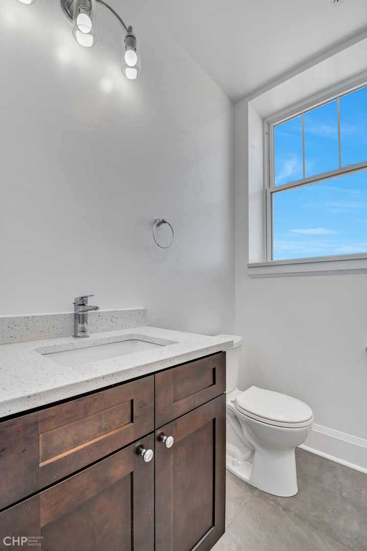2100 North Halsted Street, Unit 4R Chicago, IL 60614 - Photo 13 of 26 a bathroom with a granite countertop sink a toilet and a mirror