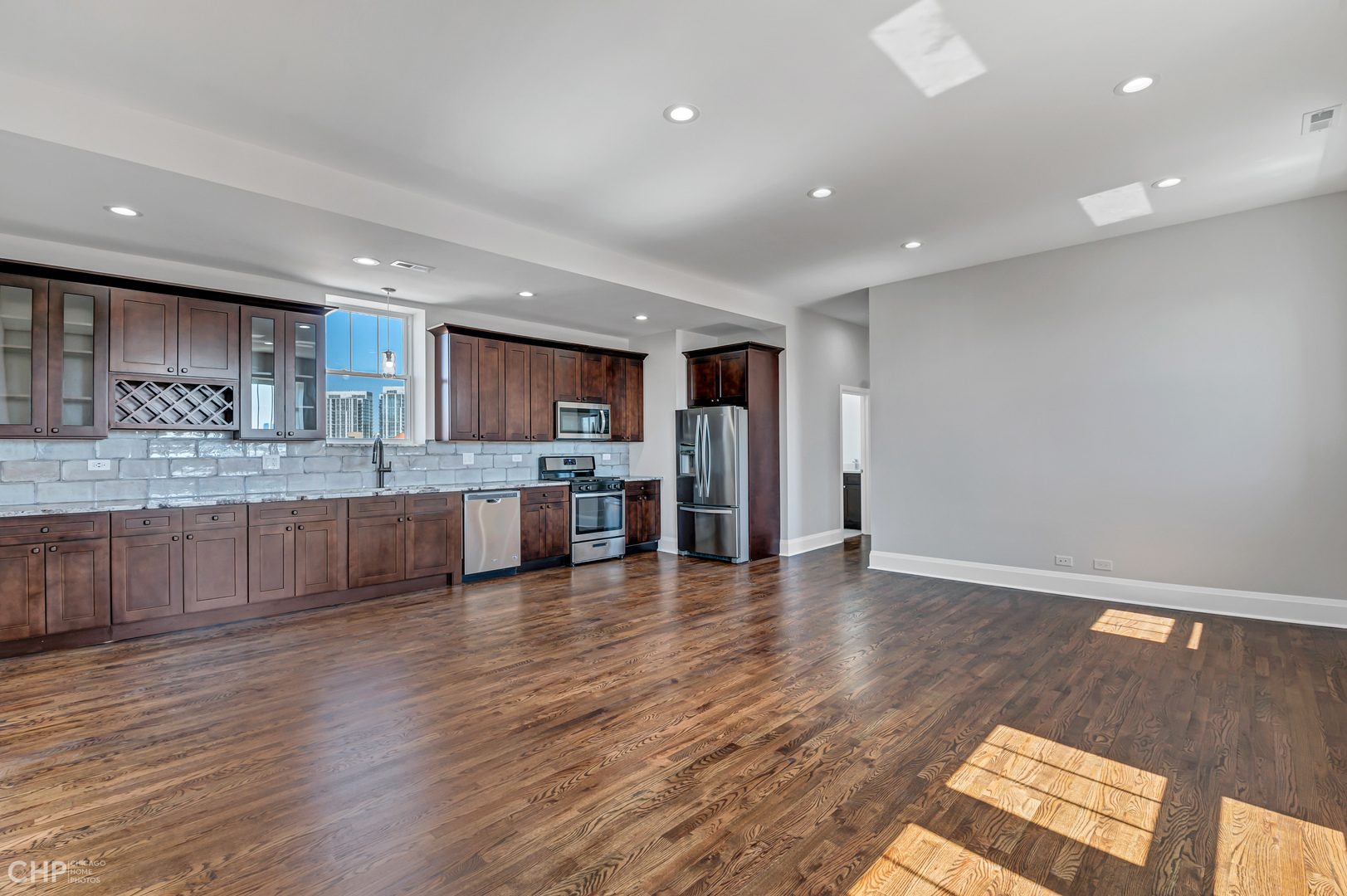 2100 North Halsted Street, Unit 4R Chicago, IL 60614 - Photo 3 of 26 a large kitchen with stainless steel appliances granite countertop a large counter top and a wooden floors