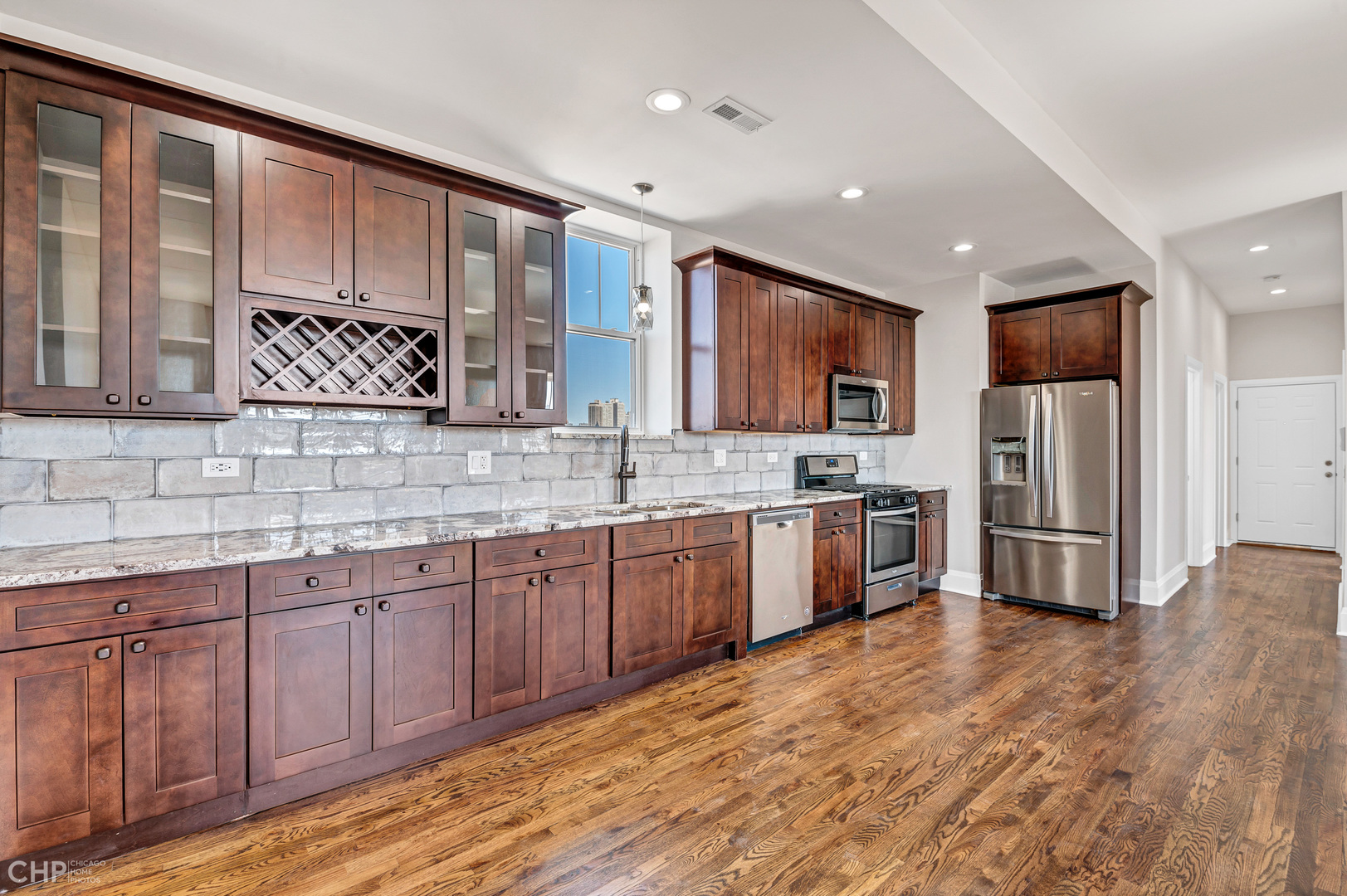 2100 North Halsted Street, Unit 4R Chicago, IL 60614 - Photo 6 of 26 a large kitchen with stainless steel appliances wooden cabinets a stove a sink and a granite counter tops