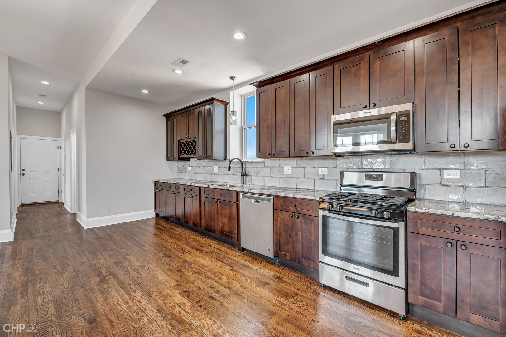 2100 North Halsted Street, Unit 4R Chicago, IL 60614 - Photo 8 of 26 a kitchen with stainless steel appliances kitchen island granite countertop a stove a sink and a microwave