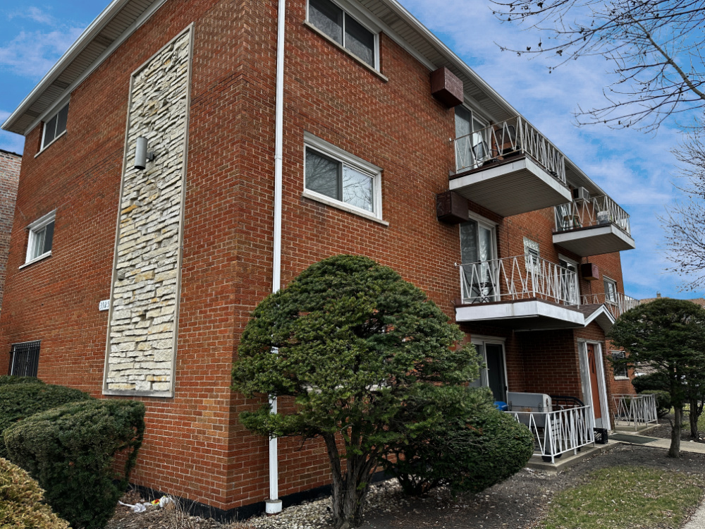 3925 West 47th Street, Unit 3N Chicago, IL 60632 - Photo 1 of 14 a front view of a house with a garden