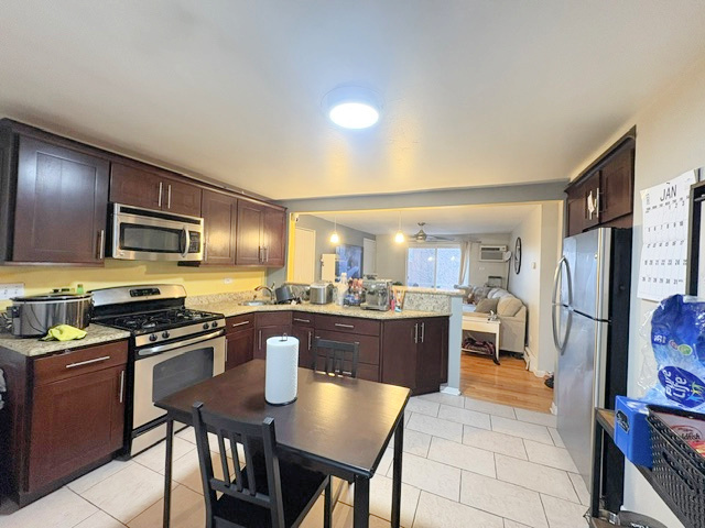 3925 West 47th Street, Unit 3N Chicago, IL 60632 - Photo 2 of 14 a kitchen with stainless steel appliances granite countertop a stove a refrigerator a kitchen island a table and chairs