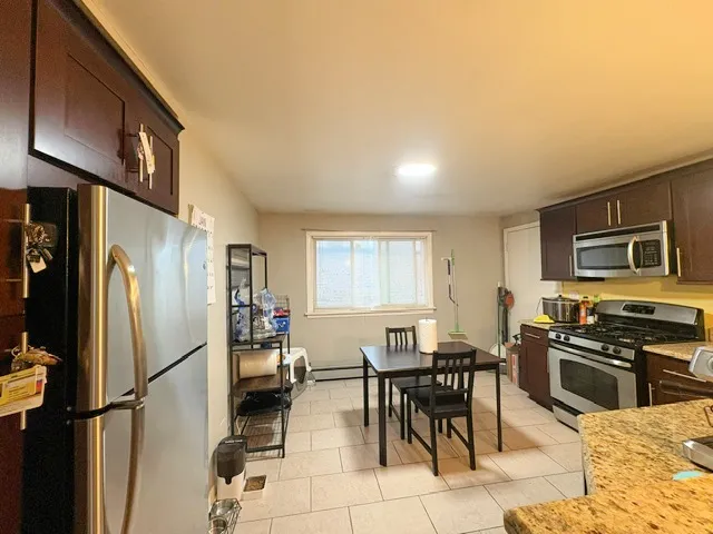 a kitchen with stainless steel appliances granite countertop a refrigerator and a stove top oven