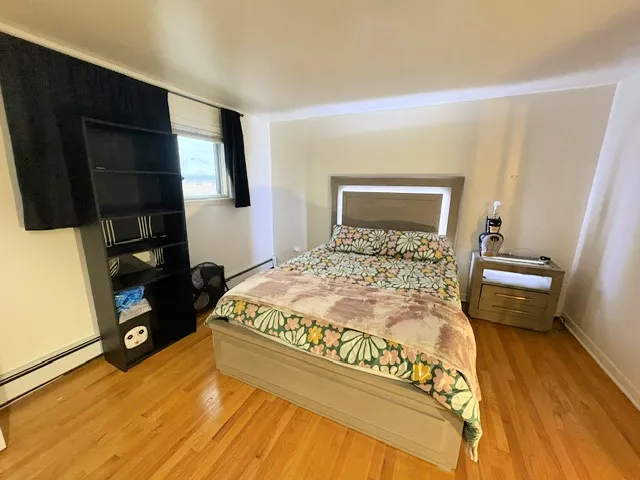 a bedroom with a bed and wooden floor