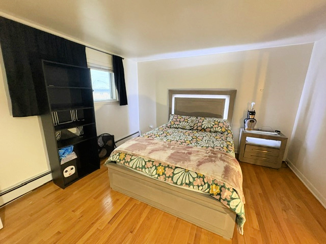 3925 West 47th Street, Unit 3N Chicago, IL 60632 - Photo 9 of 14 a bedroom with a bed and wooden floor