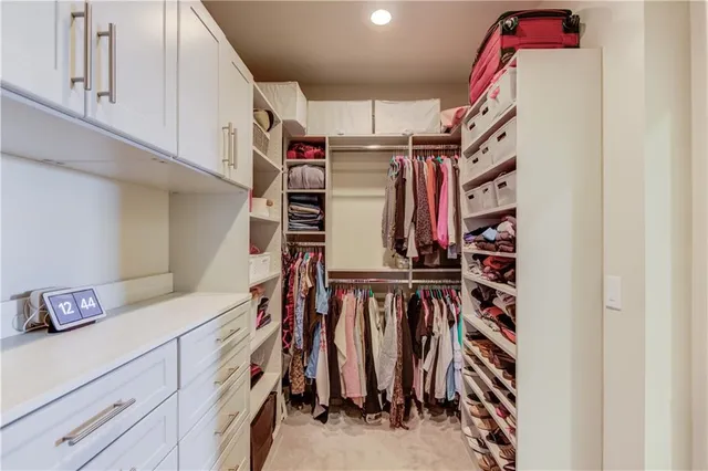 a view of walk in closet with clothes and shoes