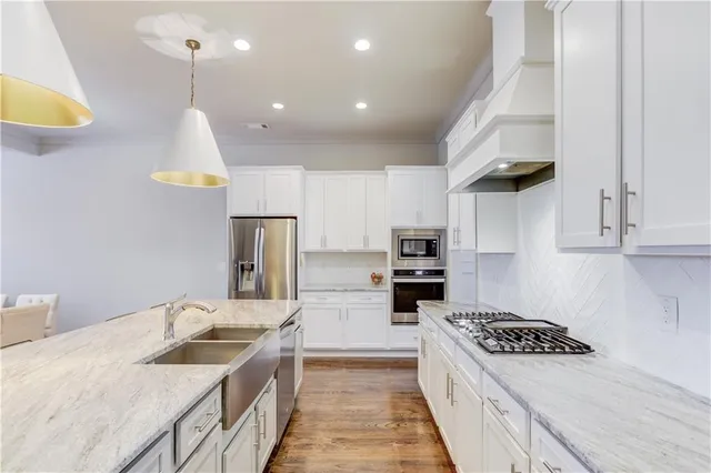 a kitchen with stainless steel appliances granite countertop a sink stove and refrigerator
