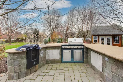 a view of a house with a yard and large tree