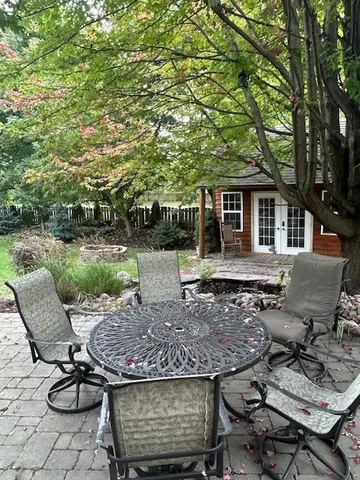 a view of a patio with table and chairs and potted plants with large tree
