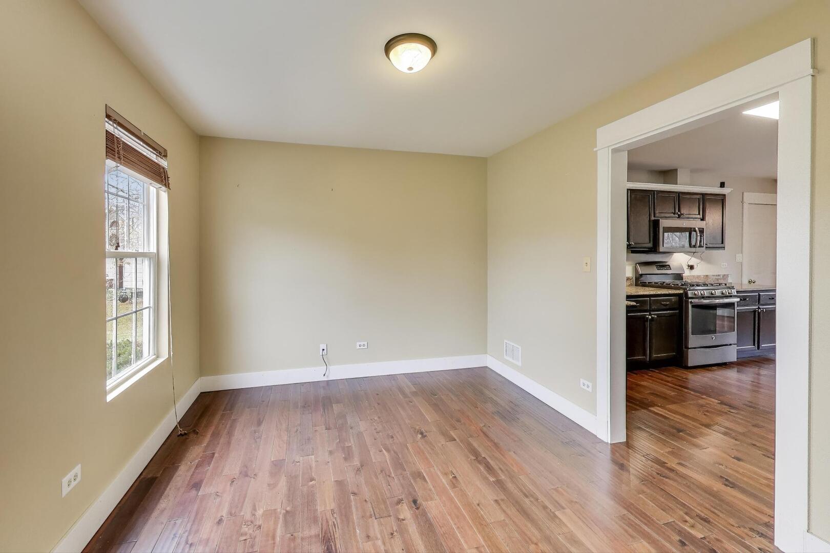 25023 Round Barn Road Plainfield, IL 60585 - Photo 8 of 44 wooden floor in kitchen and empty room with kitchen view