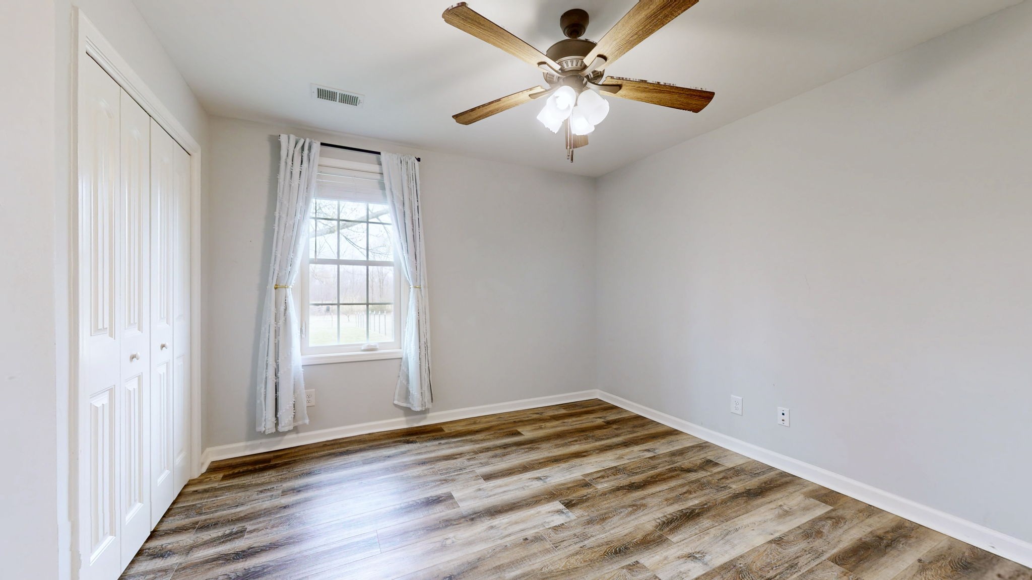 7563 South Swift Road Goodlettsville, TN 37072 - Photo 9 of 25 an empty room with wooden floor fan and windows