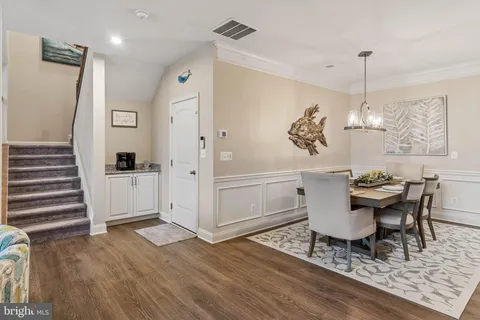 a view of a dining room with furniture wooden floor and chandelier