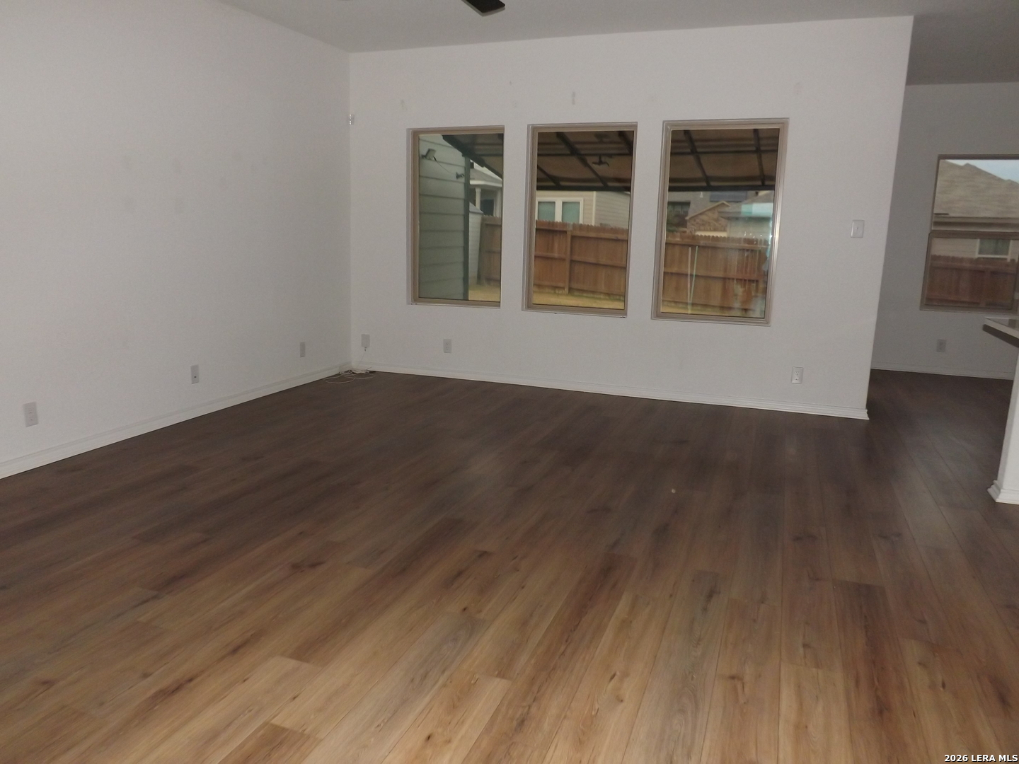 6835 Alaskan Wy. Converse, TX 78109 - Photo 4 of 22 a view of an empty room with wooden floor and windows