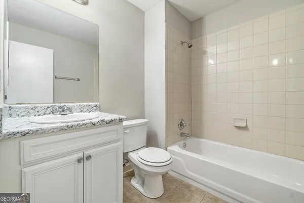 a bathroom with a granite countertop toilet a sink and a bathtub