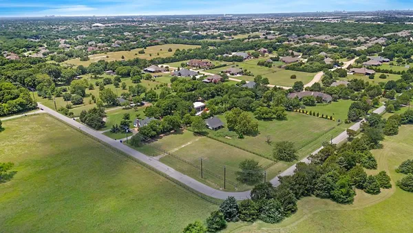 an aerial view of residential houses with outdoor space and trees
