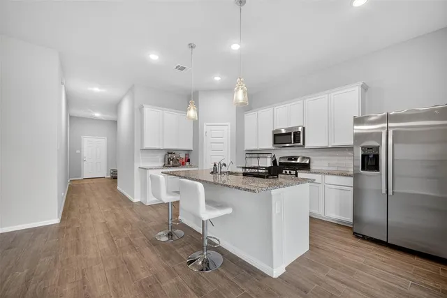 a kitchen with kitchen island granite countertop wooden cabinets and a stove