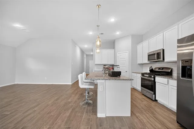 a kitchen with a sink a microwave and cabinets