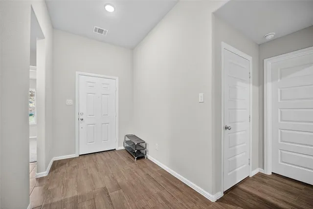 an empty room with wooden floor and closet