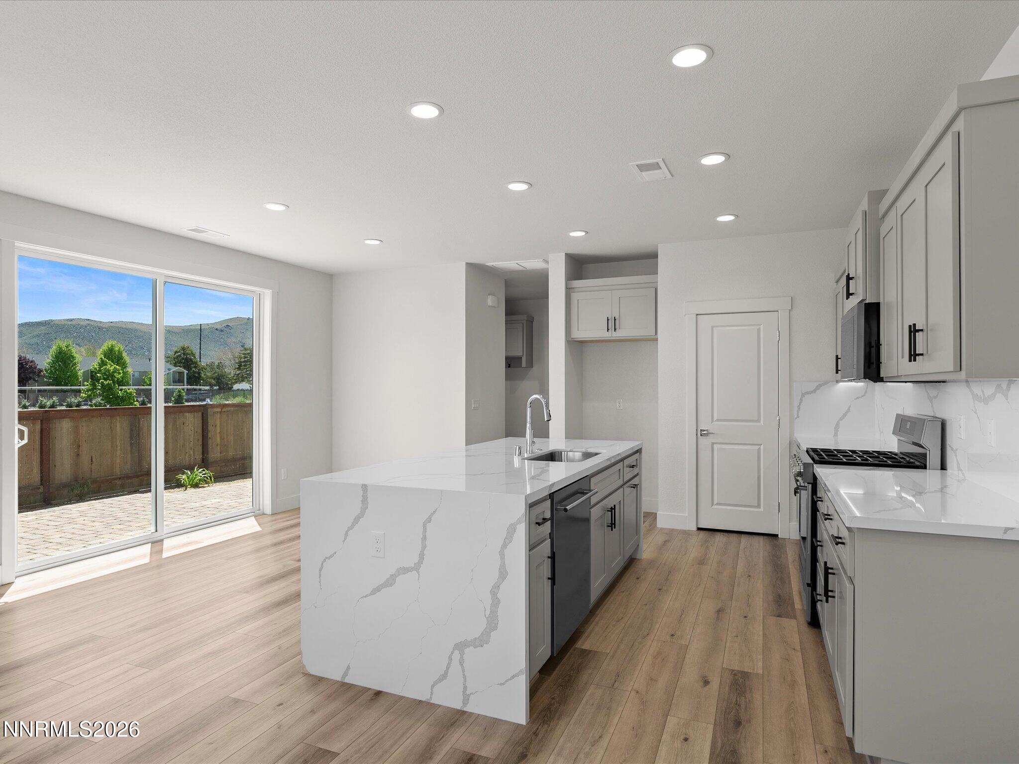 1383 Vine Gate Road, Unit HOMESITE 51 Carson City, NV 89701 - Photo 11 of 20 a large kitchen with stainless steel appliances granite countertop a stove and a wooden floors