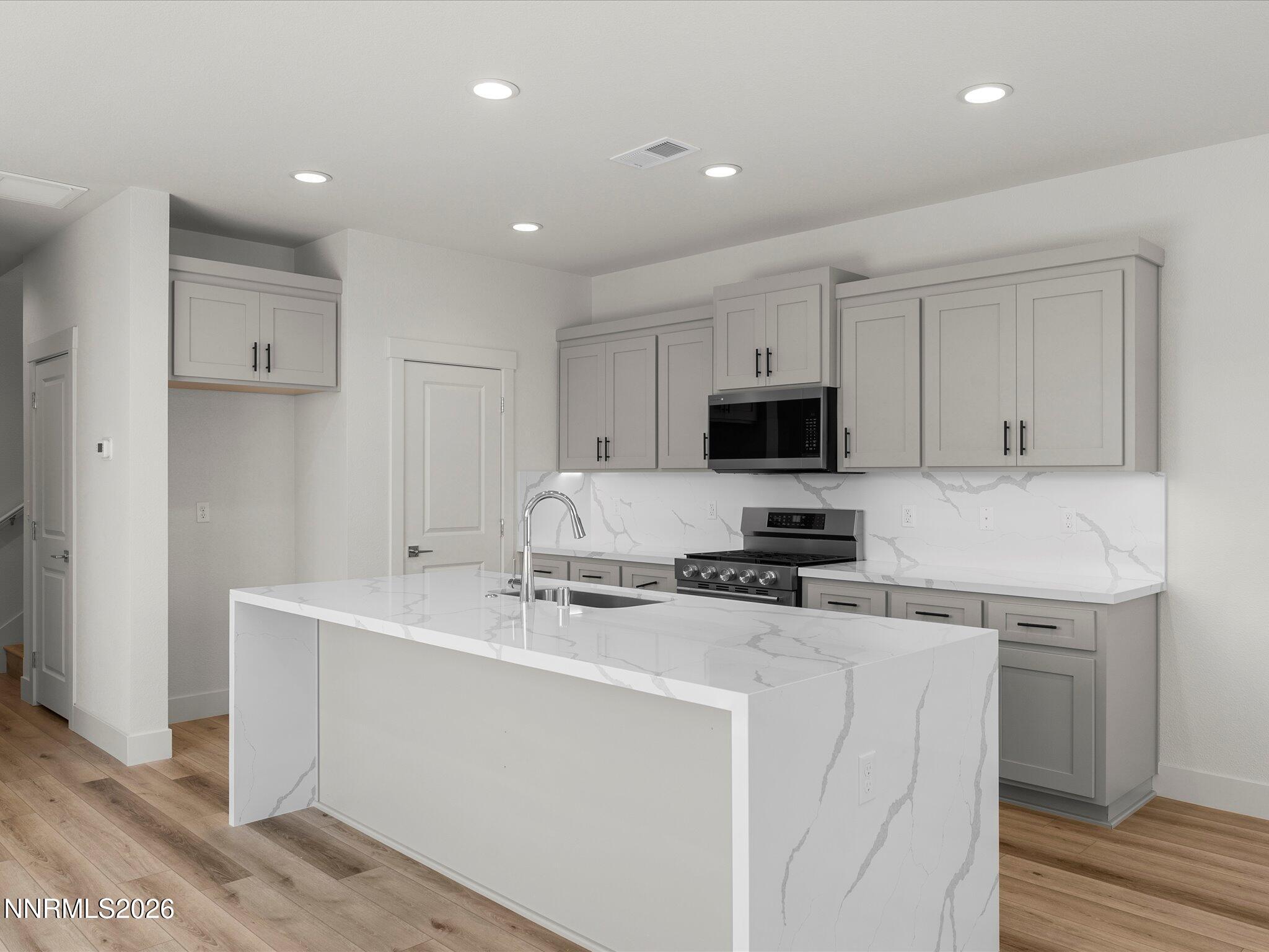 1383 Vine Gate Road, Unit HOMESITE 51 Carson City, NV 89701 - Photo 4 of 20 a kitchen with stainless steel appliances a stove a sink a microwave and cabinets