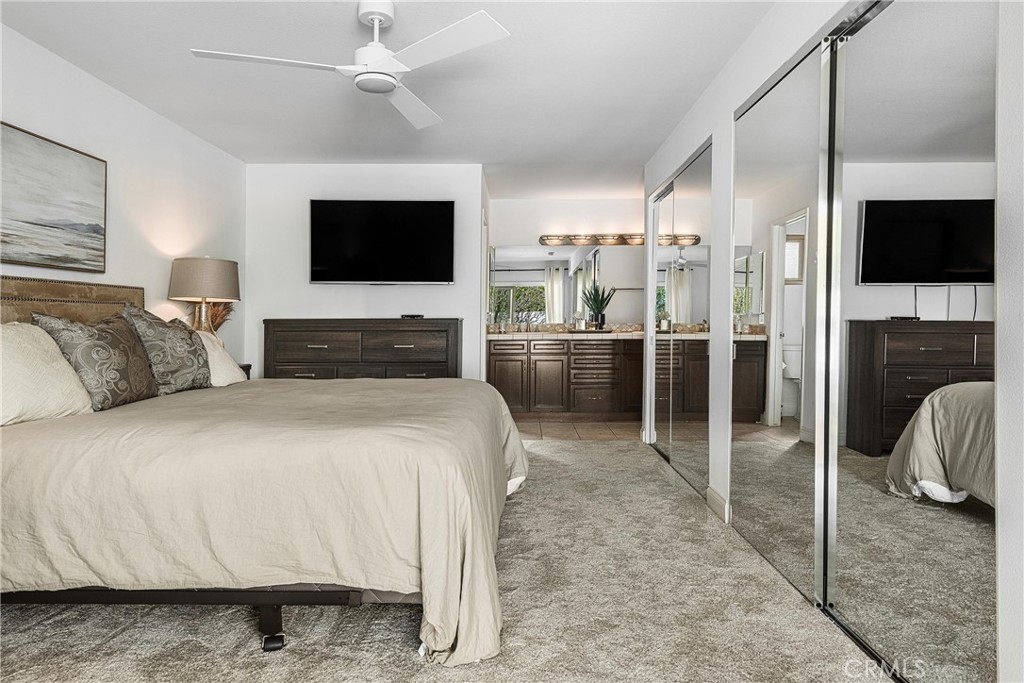 73425 Haystack Road Palm Desert, CA 92260 - Photo 25 of 30 a spacious bedroom with a bed and a flat screen tv