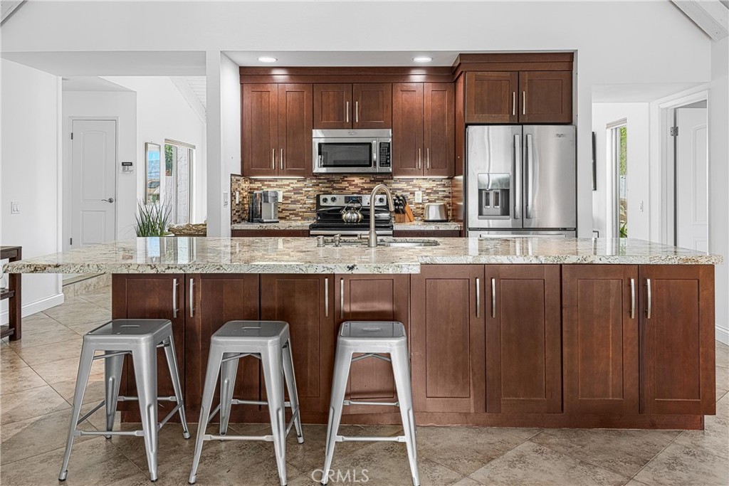 73425 Haystack Road Palm Desert, CA 92260 - Photo 8 of 30 a kitchen with kitchen island granite countertop wooden cabinets and stainless steel appliances
