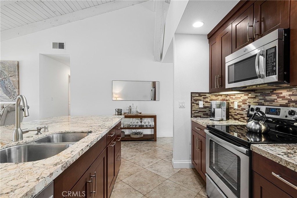 73425 Haystack Road Palm Desert, CA 92260 - Photo 9 of 30 a kitchen with stainless steel appliances granite countertop a sink stove and microwave