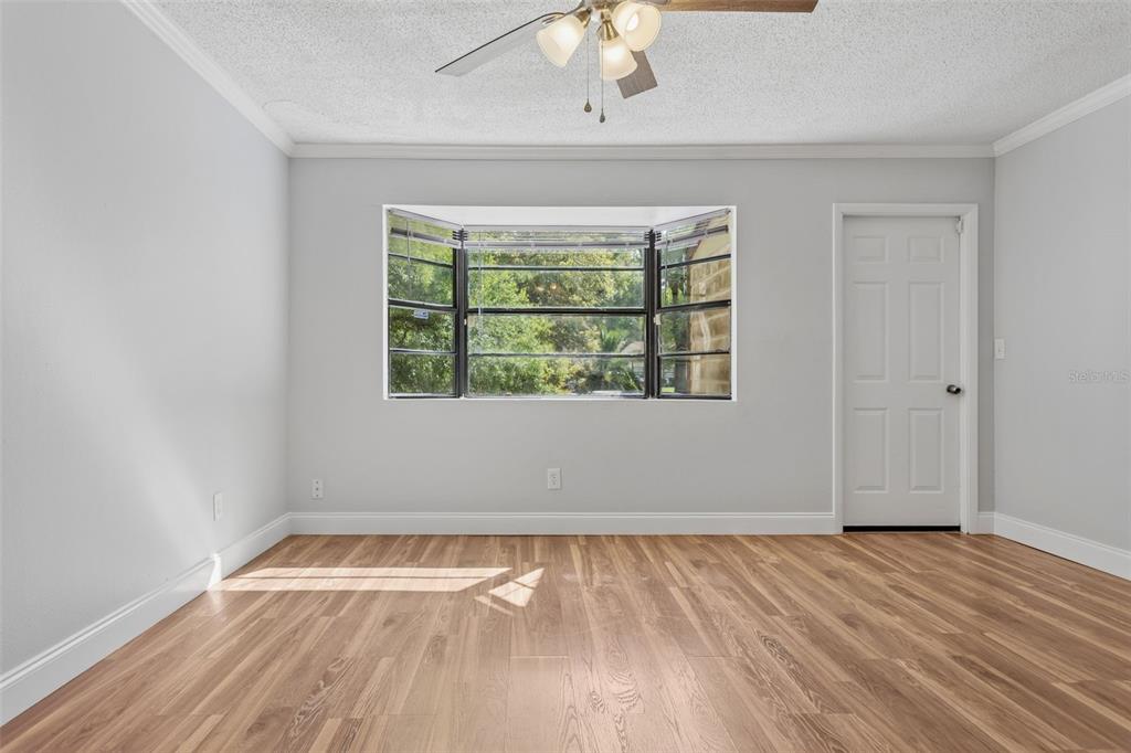 10307 Councils Way Temple Terrace, FL 33617 - Photo 22 of 50 an empty room with wooden floor chandelier fan and windows