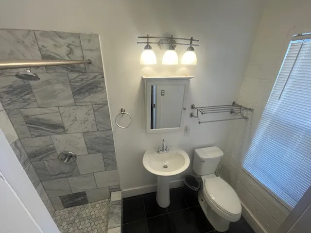 a bathroom with a sink toilet a mirror and shower