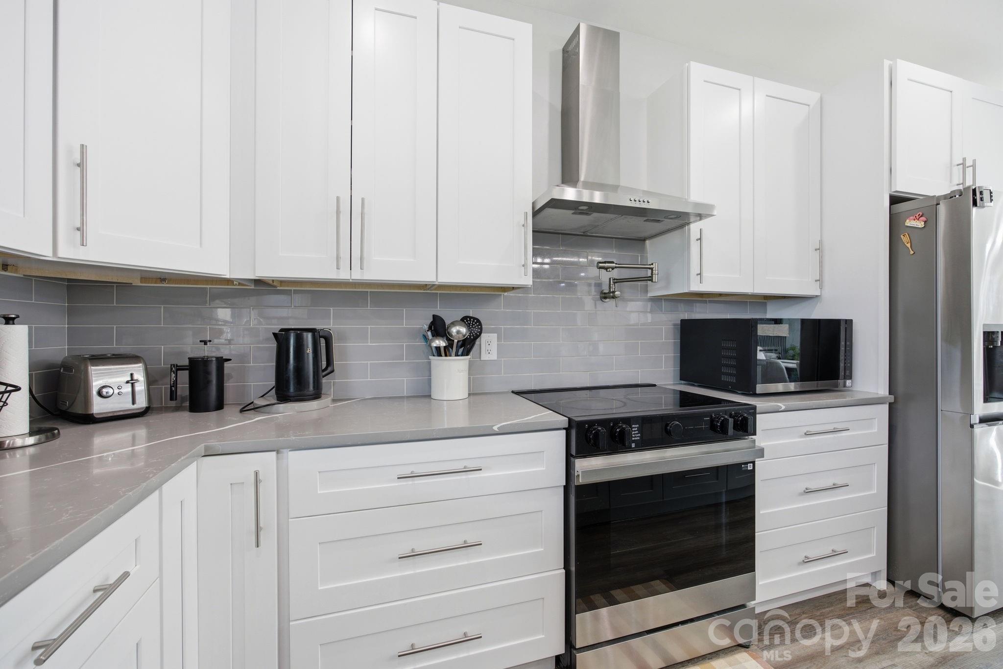 30 1st Street Canton, NC 28716 - Photo 13 of 39 a kitchen with stainless steel appliances granite countertop a stove a sink and a white cabinets