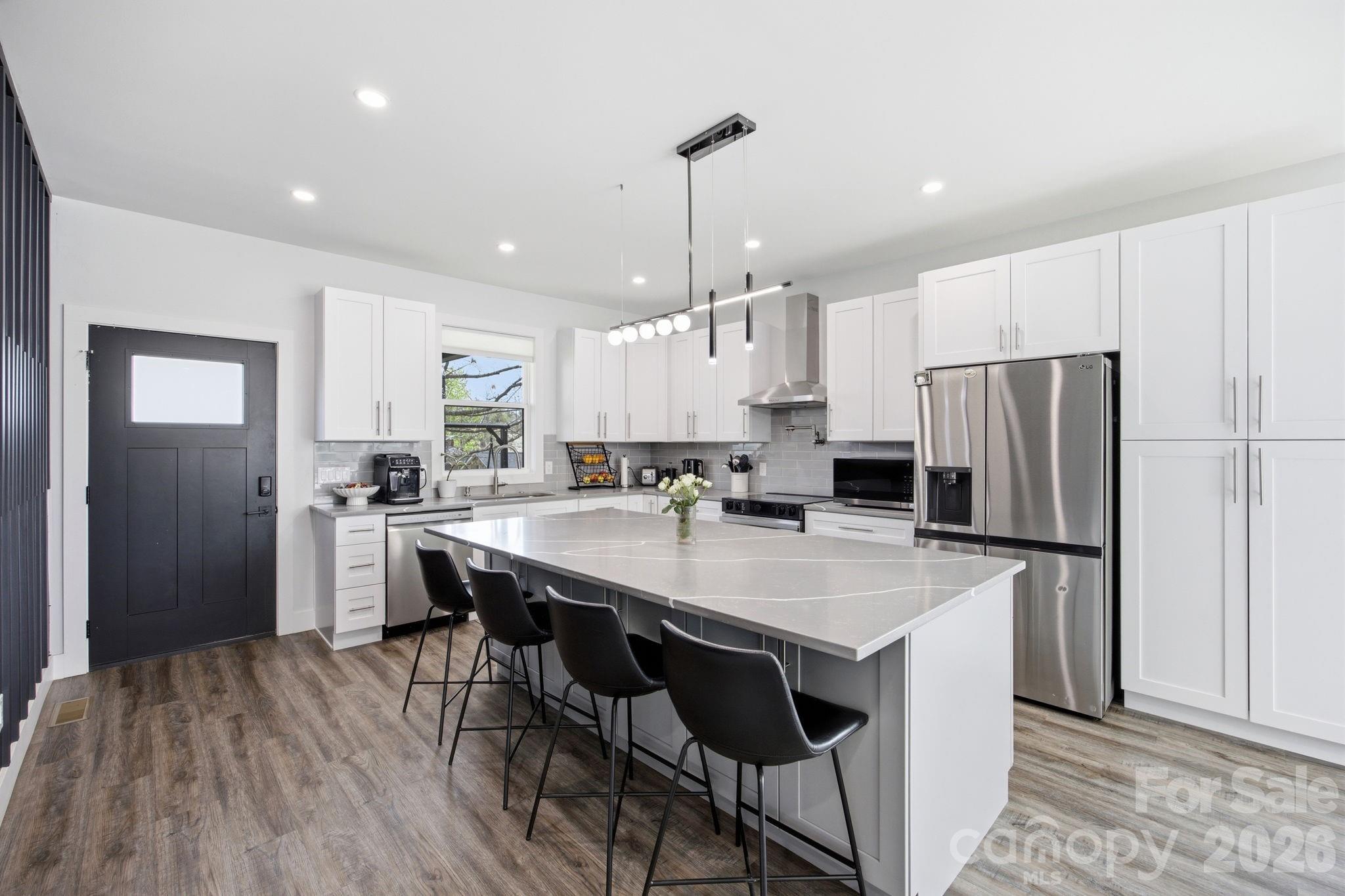 30 1st Street Canton, NC 28716 - Photo 14 of 39 a kitchen with stainless steel appliances a refrigerator a stove a sink and a refrigerator with wooden floor
